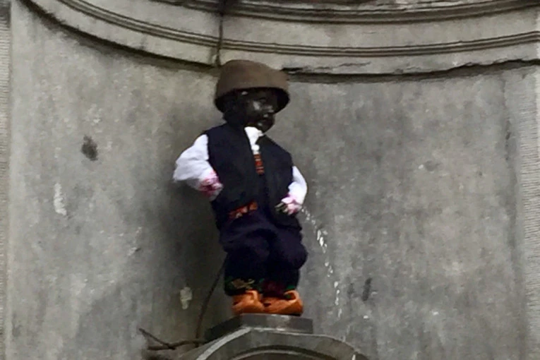 (FOTO) MANEKEN PIS dobio novo ruho u skladu sa koronom: Olakšava se u belom mantilu