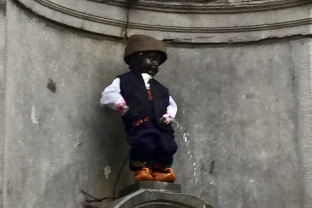 (FOTO) MANEKEN PIS dobio novo ruho u skladu sa koronom: Olakšava se u belom mantilu