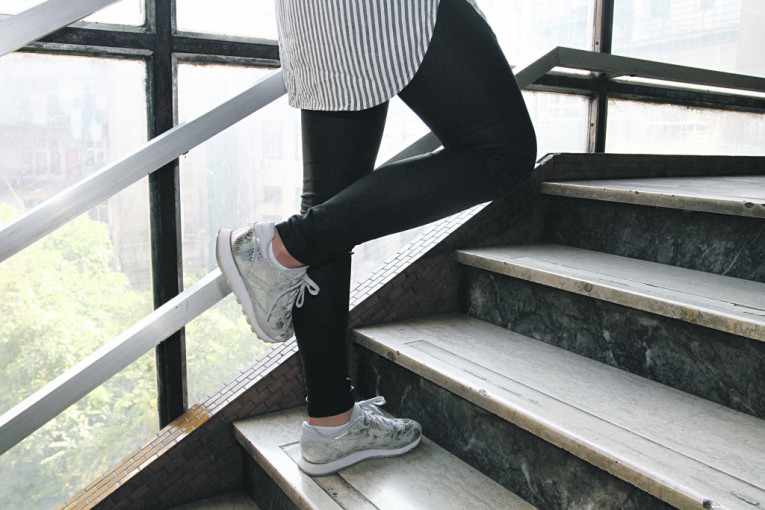 VEŽBA 2
Korak 1: Stanite celim stopalom jedne noge na stepenik, a drugu nogu savijte u kolenu i stopalo pozicionirajte iza kolena noge na koju se oslanjate.