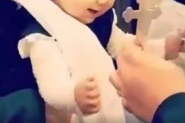 (VIDEO) Ovo je prava mala Srpkinja! Beba oduševila na krštenju: Sama hvata krst, privlači ga i ljubi!