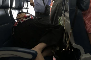 (FOTO) Džentlmen ili mlakonja? Stajao u avionu 6 sati da bi mu žena spavala na 3 sedišta