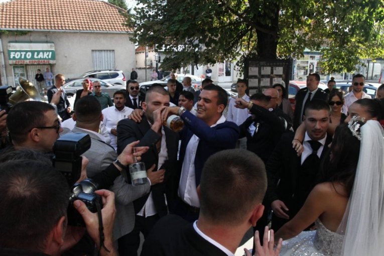 VELJKO NAZDRAVLJA ZA MLADENCE! Ražnatović potegao rakiju iz FLAŠE, slavlje ispred crkve uz TRUBAČE! (FOTO)