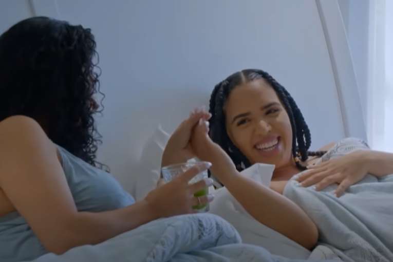 Majka i ćerka leže u krevetu i drže se za ruke