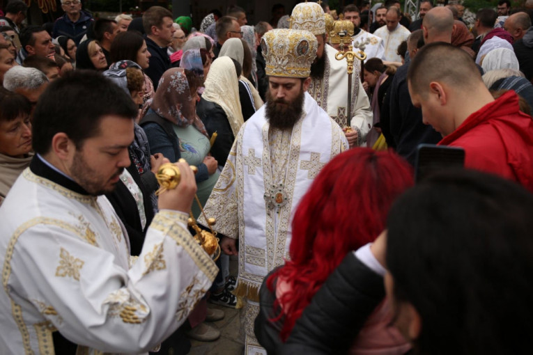 Sveštenici prolaze pored ljudi ispred Tumana