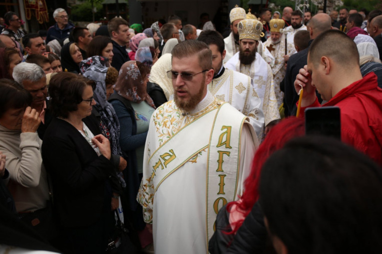 Sveštenici prolaze pored vernika ispred Tumana