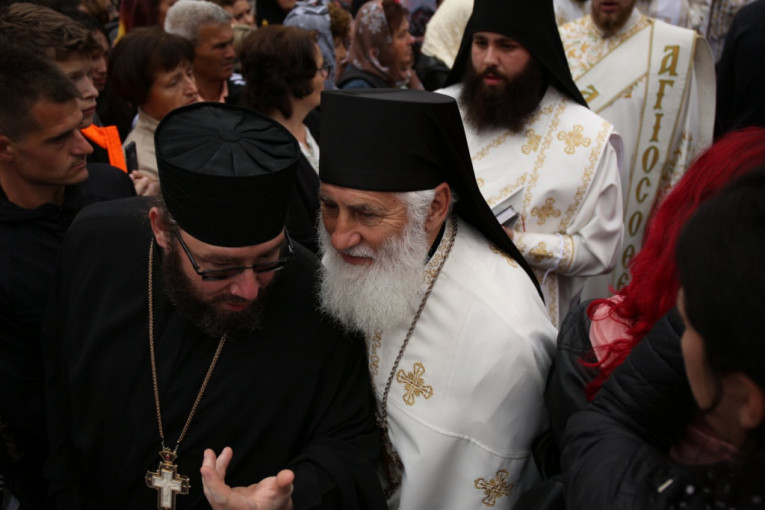 Sveštenici prolaze pored vernika ispred manastira Tumane