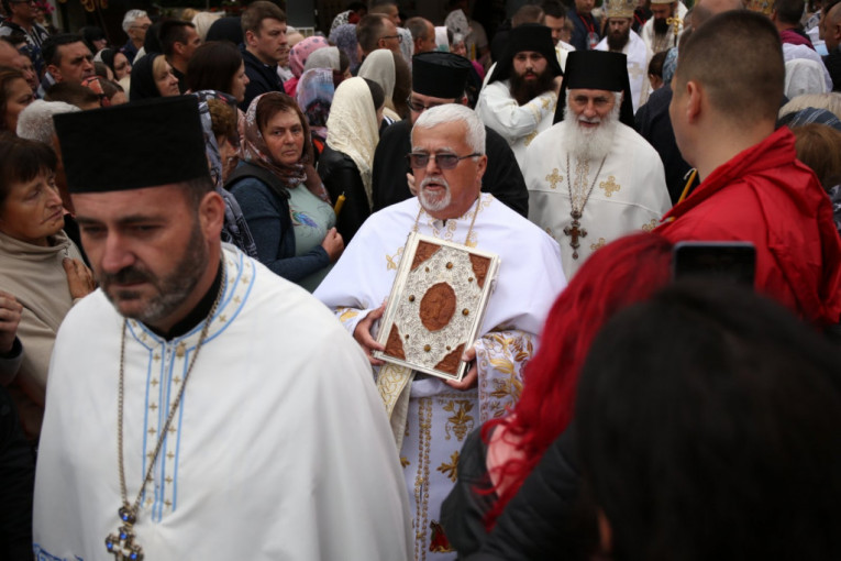 Sveštenici prolaze pored vernika ispred manastira