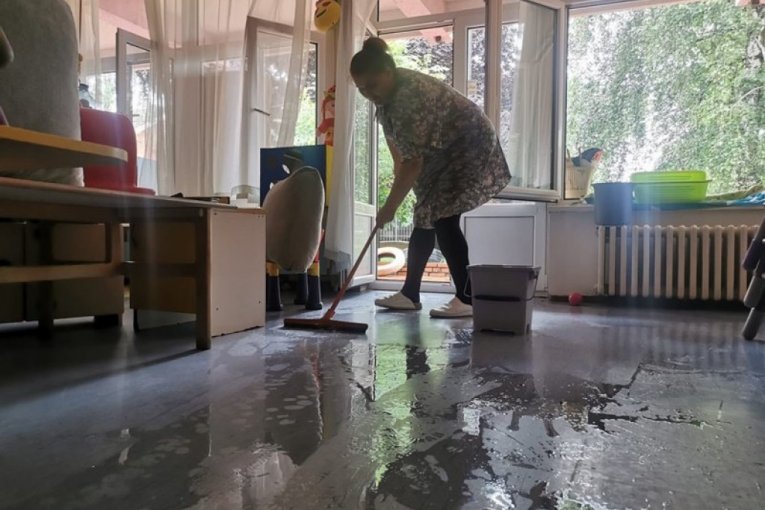 Žena čisti poplavljenu kuću 