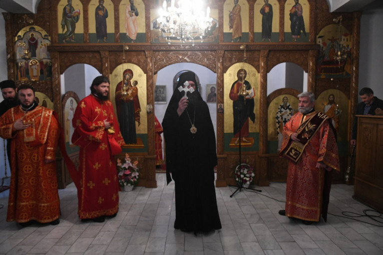 Vladika Ilarion drži krst